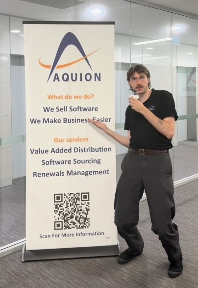 Man presenting next to Aquion banner displaying software services including value added distribution, sourcing and renewals management